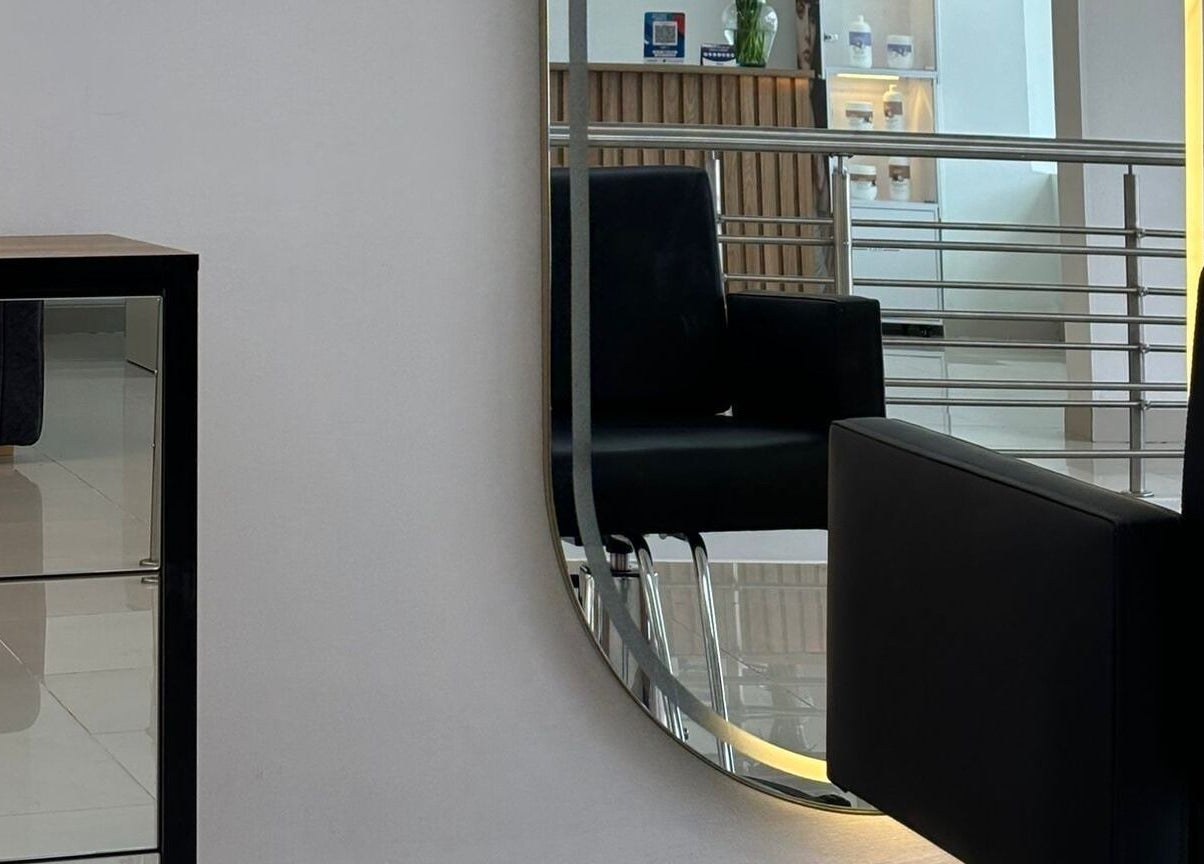 Interior elegante en LUXURY STUDIO MB, Bogotá, con silla y espejo iluminado moderno.