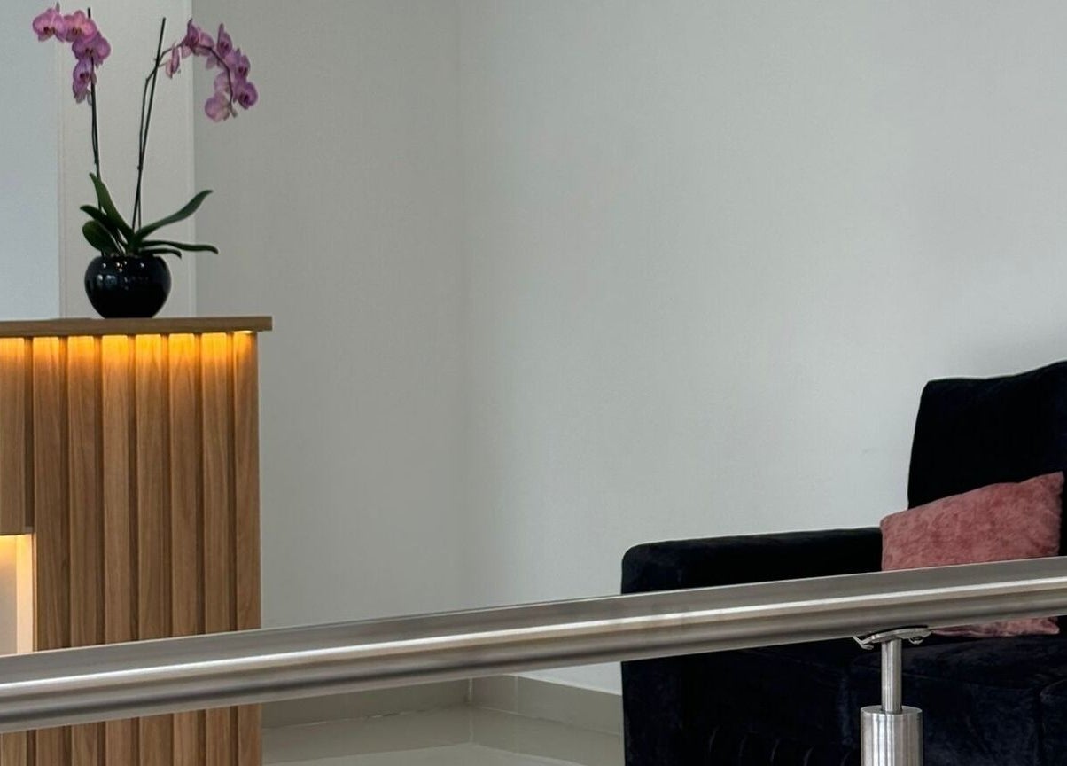Sala de espera elegante en Luxury Studio MB, Bogotá, Bogotá, CO con sofá y orquídea.
