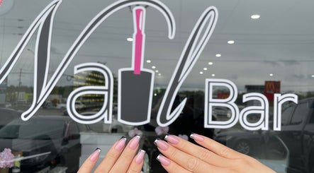Stylish manicure at The Nail Bar, Oshawa, Ontario, CA with elegant nail art in front of the venue logo.