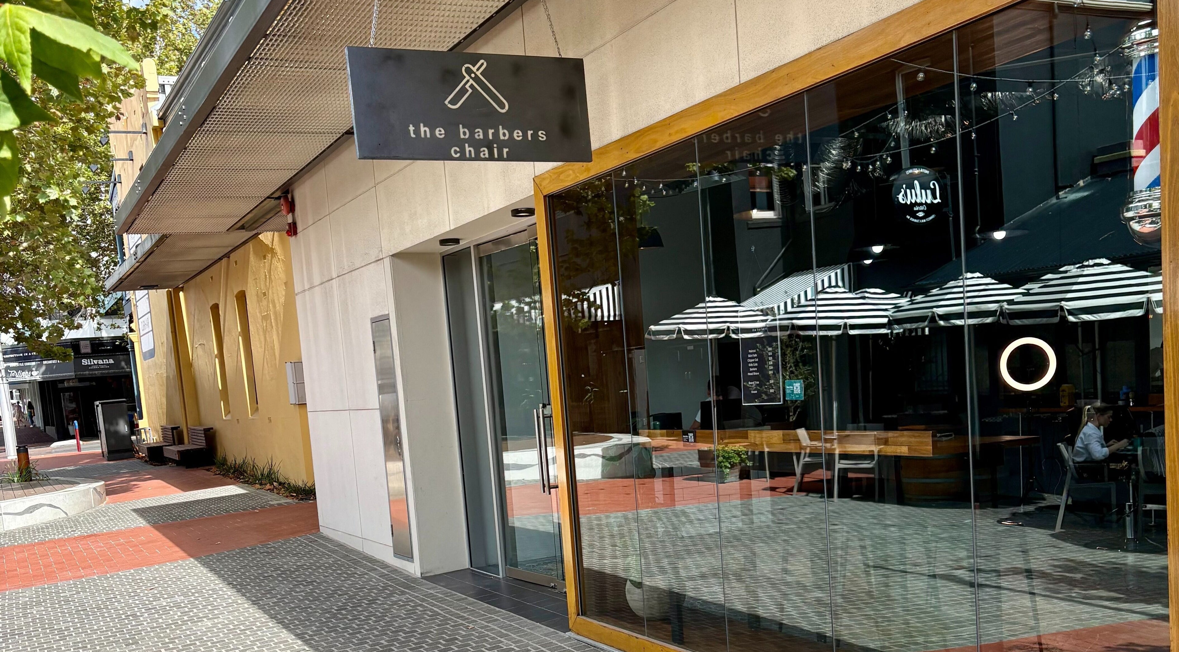 Street view of The Barbers Chair in Subiaco, Western Australia, AU. Glass facade and inviting entrance.