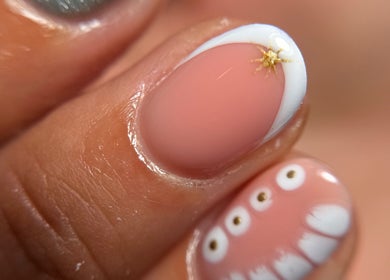 Elegant nail art at Blessed Nails in Kangaroo Point, Queensland, AU, featuring unique gold and white designs.