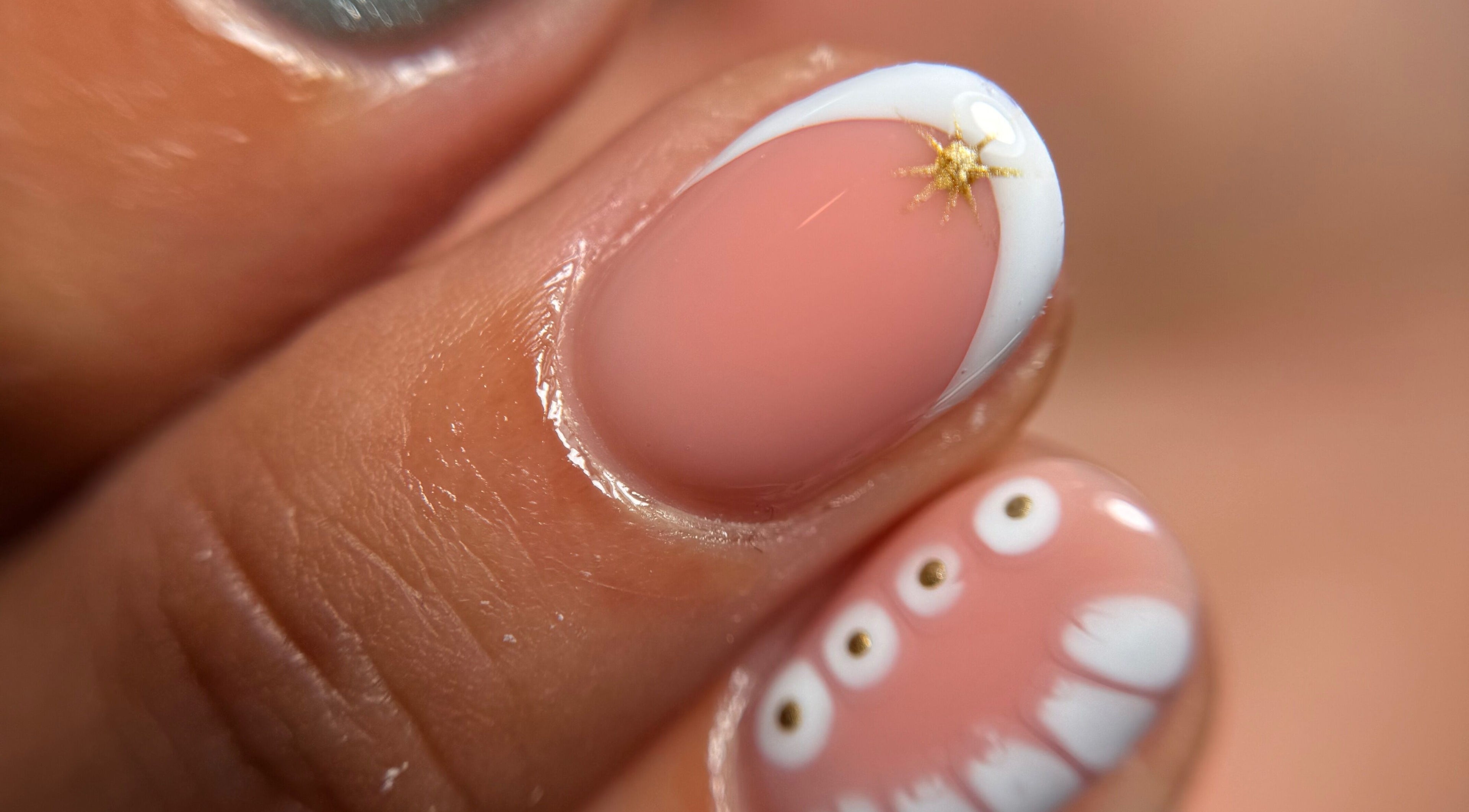 Elegant nail art at Blessed Nails in Kangaroo Point, Queensland, AU, featuring unique gold and white designs.