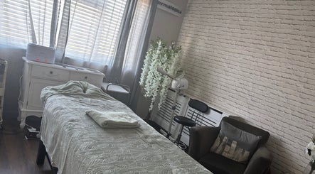 Calming treatment room at LEL’s Beauty, Tividale, England, GB, featuring a cozy massage table and elegant decor.