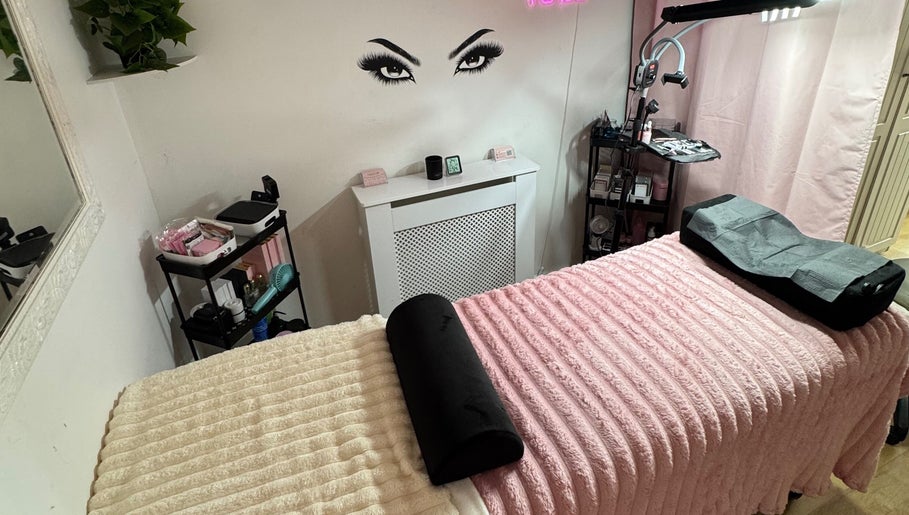 Inviting lash room at Lashed By Xio in London, England, GB with soft pink decor and treatment bed.