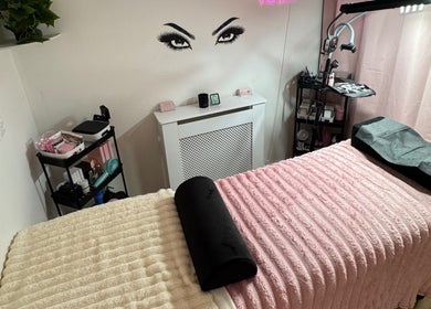 Inviting lash room at Lashed By Xio in London, England, GB with soft pink decor and treatment bed.