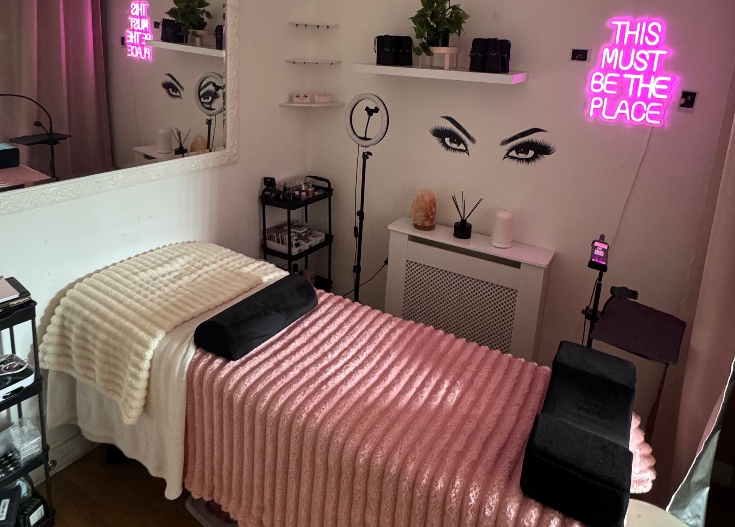 Cozy lash treatment room at Lashed By Xio, London, England, GB with pink decor and elegant ambiance.