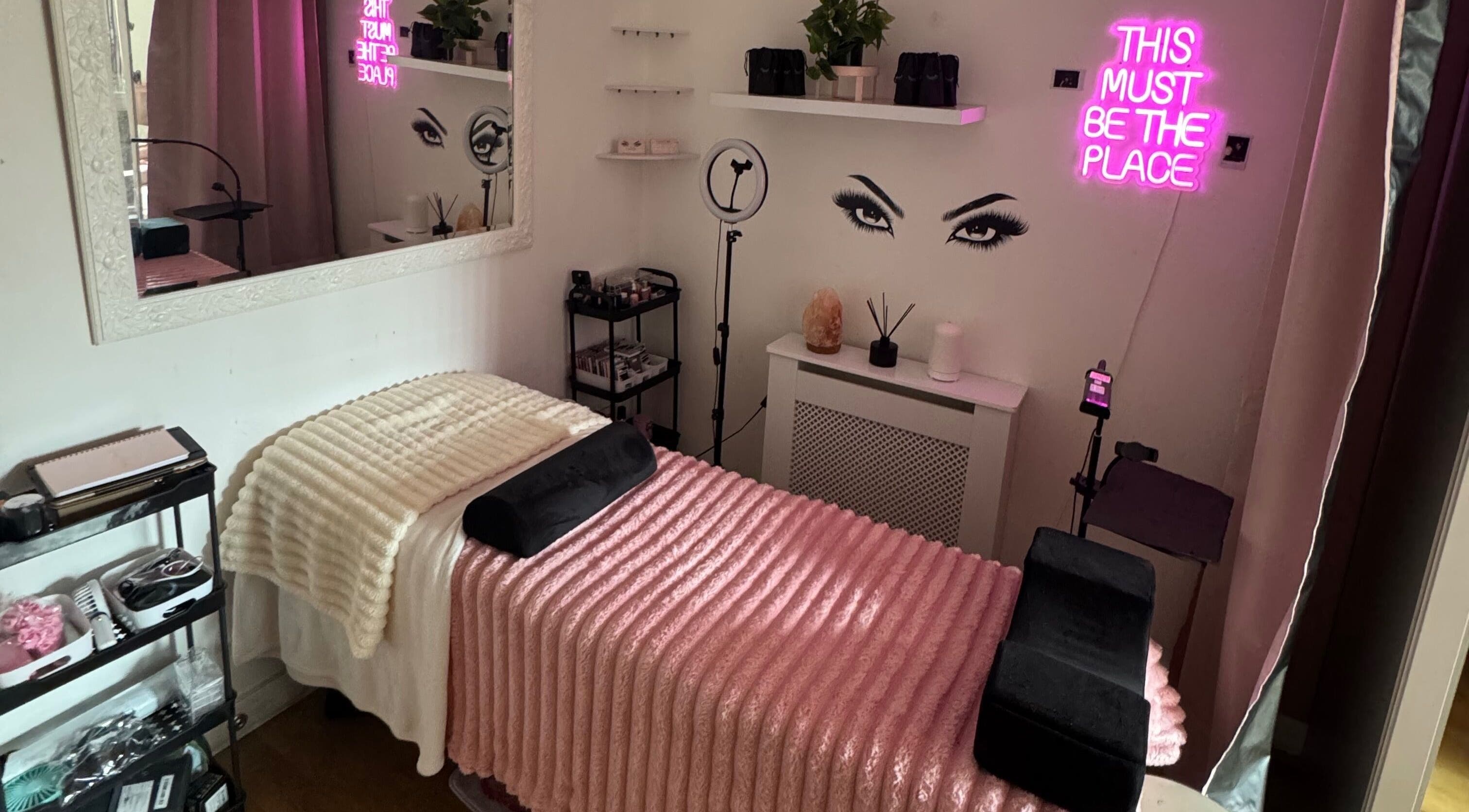 Cozy lash treatment room at Lashed By Xio, London, England, GB with pink decor and elegant ambiance.