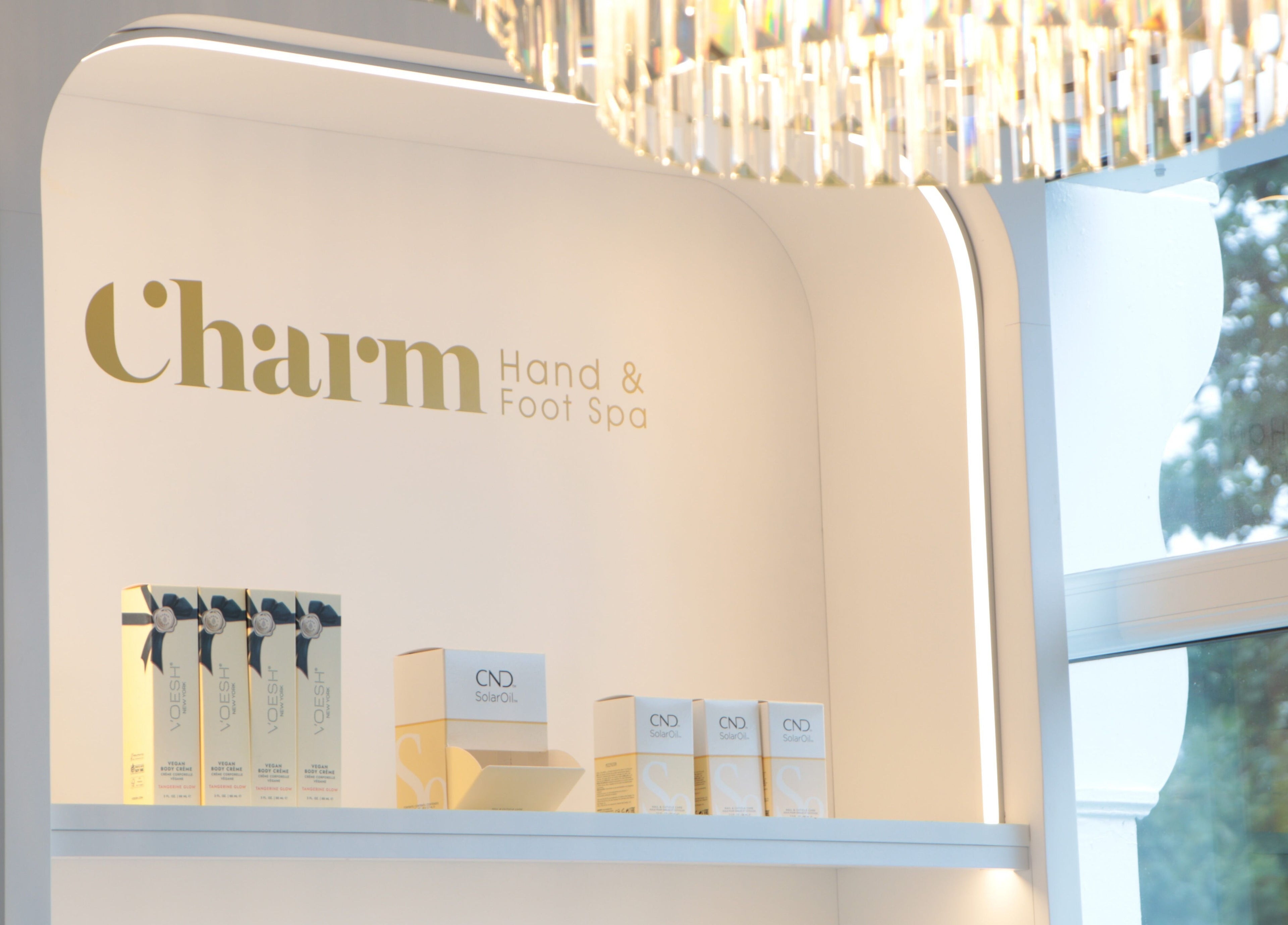 Product display at Charm of Howth, Dublin, County Dublin, IE, showcasing spa essentials under a chandelier.