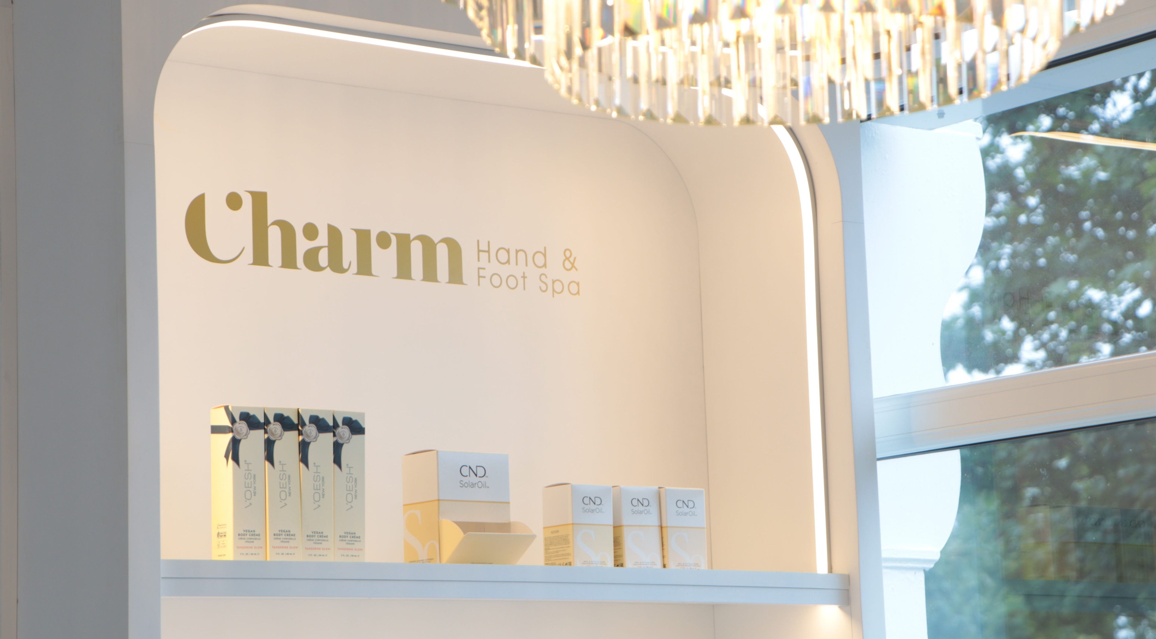 Product display at Charm of Howth, Dublin, County Dublin, IE, showcasing spa essentials under a chandelier.