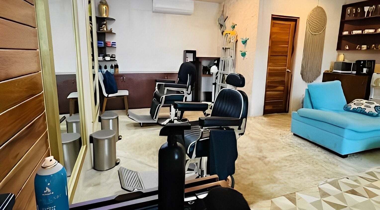 Interior de The Gold Barber Shop en Tulum, Quintana Roo, MX con sillas de cliente y decoración moderna.
