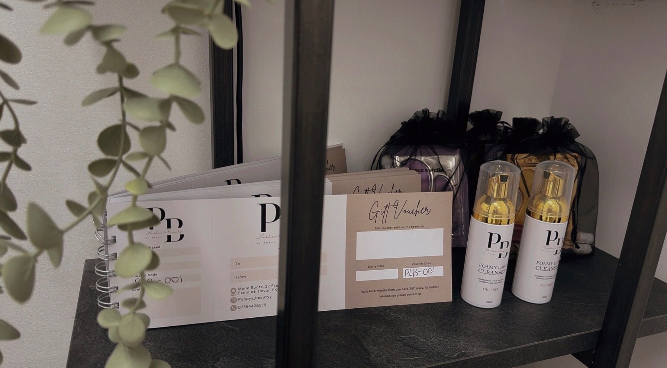 Gift vouchers and cleansers at Poppys Lashes & Beauty, Exmouth, England, GB, elegantly arranged on a shelf.