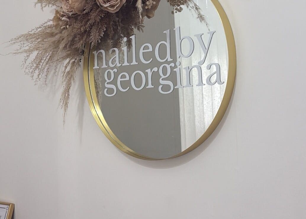 Decorative mirror with 'Nailedbygeorgina' logo at Queensbury, England, GB salon.