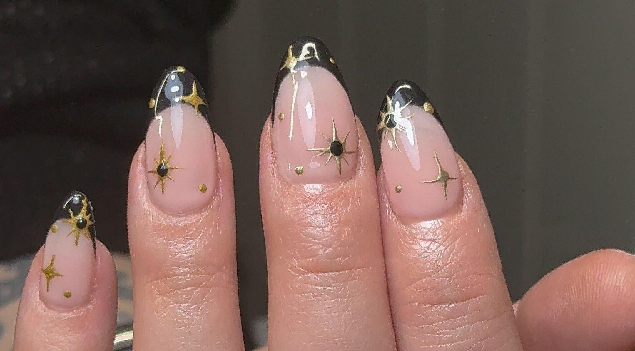 Elegant starlit nail design at Nailedbygeorgina, Queensbury, England, GB. Black tips with gold stars.