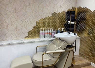 Luxurious salon sink and chair at Beauty With Raye, Bristol, England, GB with elegant gold accents.