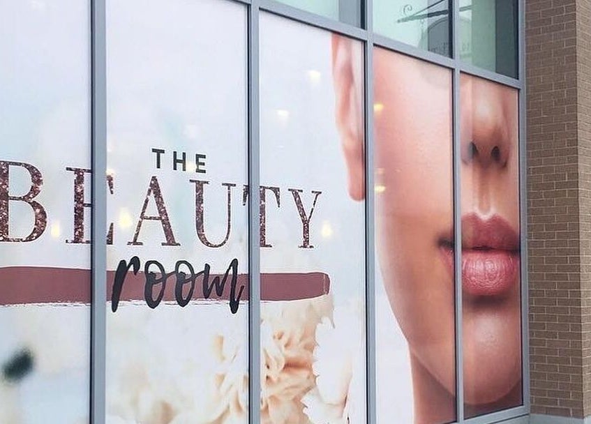 Entrance of The Beauty Room in Oshawa, Ontario, CA, featuring elegant signage on glass windows.