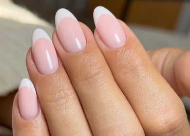 Elegant French manicure at Mika Beauty, Wilmslow, England, GB. Glossy pink nails with white tips.