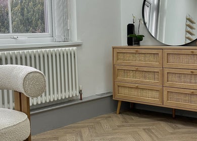 Elegant room at Mika Beauty, Wilmslow, England, GB, featuring a wood dresser, mirror, and cozy chair.