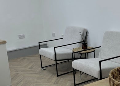 Elegant seating area in Mika Beauty, Wilmslow, England, GB with minimalist chairs and cozy decor.