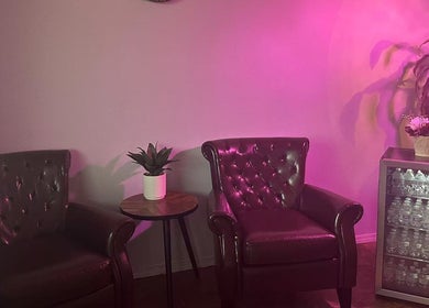 Cozy waiting area at Massage Relax & Spa, Springdale, Arkansas, US, featuring leather chairs and a mini fridge.