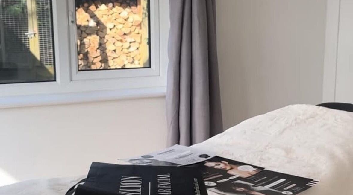 Peaceful treatment room in KEFI BEAUTY, Par, England, GB with cozy bed and reading materials.