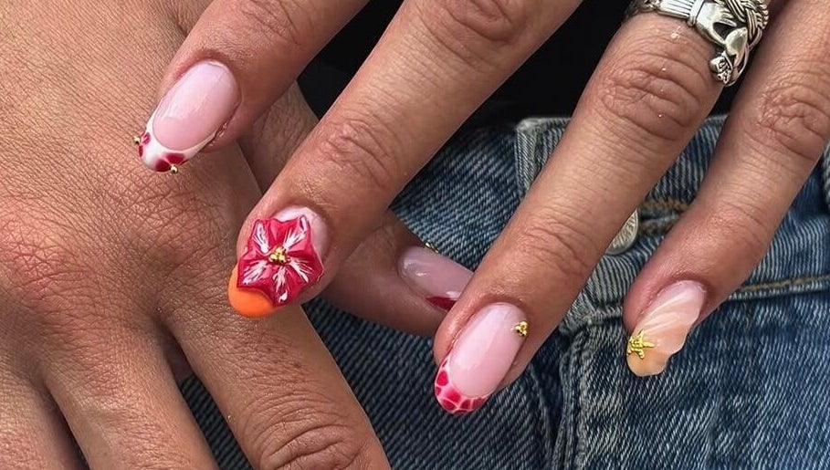 Magnifique nail art floral à Joy Nails, Niort, Nouvelle-aquitaine, FR, avec des motifs rouges et animations délicates.