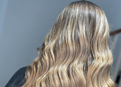 Elegant wavy hairstyle showcased at Hair By Hope, Knowle, England, GB, highlighting glossy blonde highlights.
