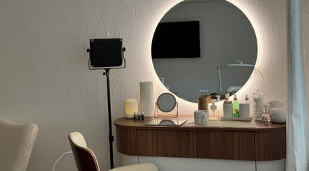 Modern vanity setup at With love, Christie in Düsseldorf, Nordrhein-westfalen, DE featuring a lit mirror.