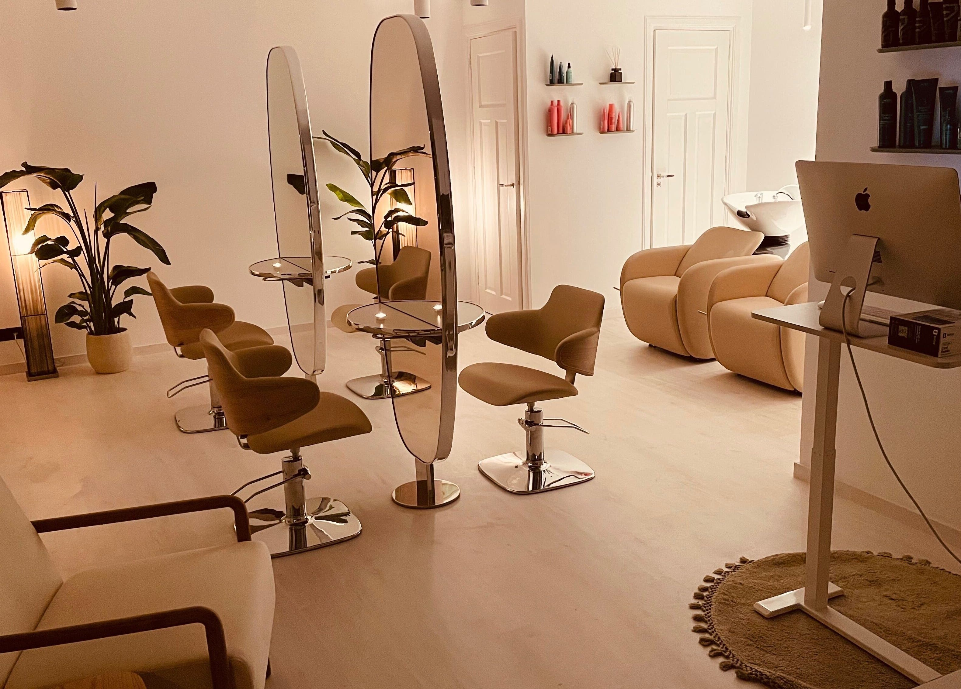 Chic interior of Shah Saatchi in Amsterdam, Noord-Holland, NL with modern salon chairs and mirrors.