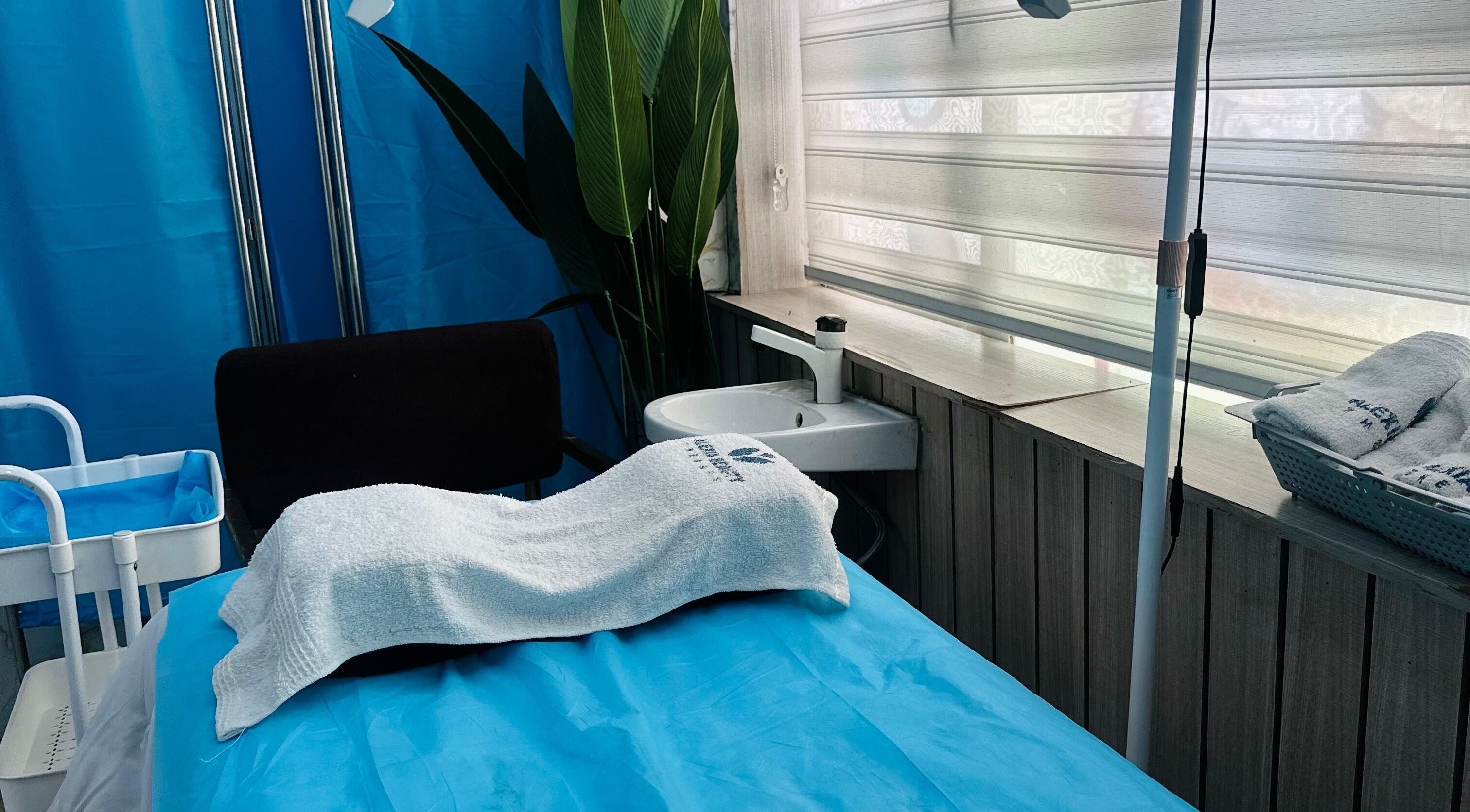 Tranquil treatment room at ABT MED SPA, Lekki, Lagos, NG with white towels and soothing blue decor.