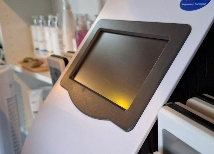 Geavanceerde schoonheidsmachine bij Twoja Uroda, Dieren, Gelderland, NL, omringd door productflessen.