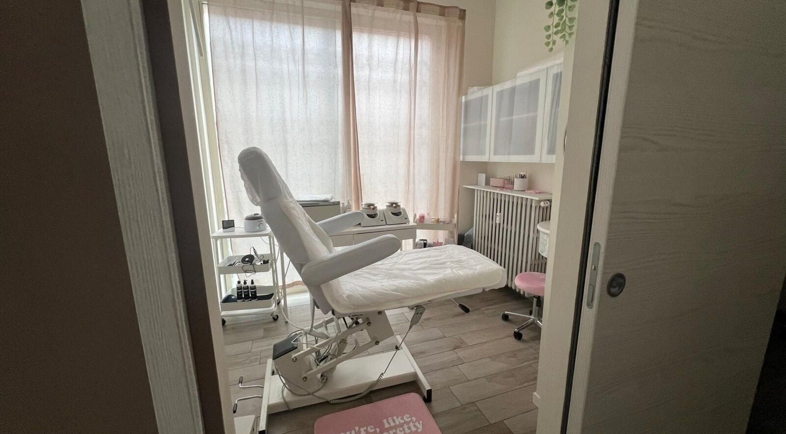 Sala di trattamenti elegante a DE BEAUTY Corner, Pinerolo, Piemonte, IT con poltrona bianca e attrezzature.