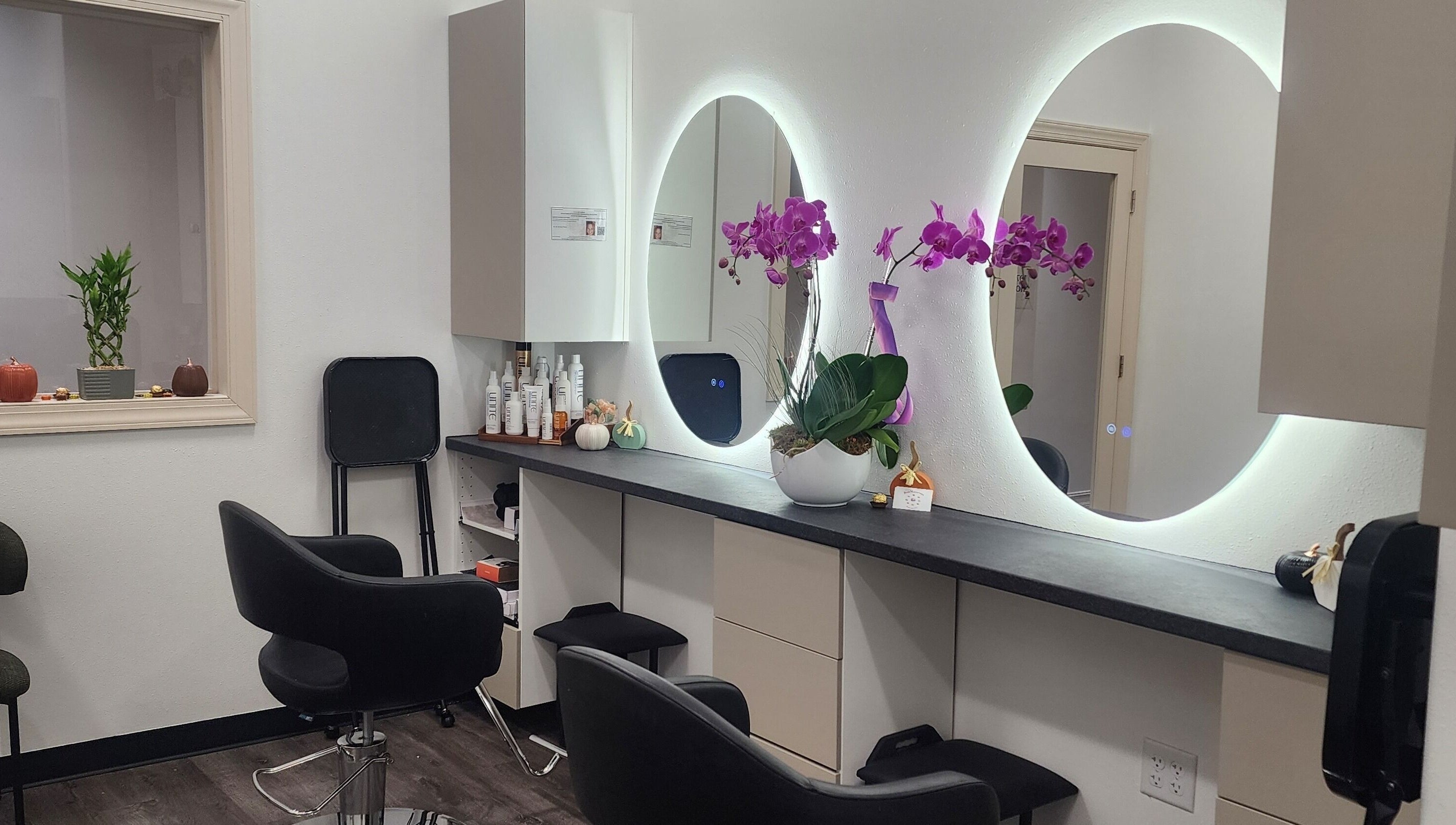 Modern salon interior at CHELLE HAIR DESIGN, Boca Raton, Florida, US, featuring stylish chairs and illuminated mirrors.