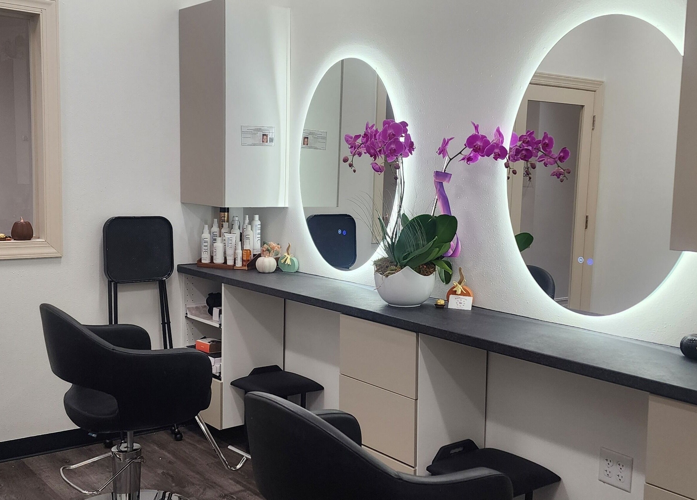 Modern salon interior at CHELLE HAIR DESIGN, Boca Raton, Florida, US, featuring stylish chairs and illuminated mirrors.