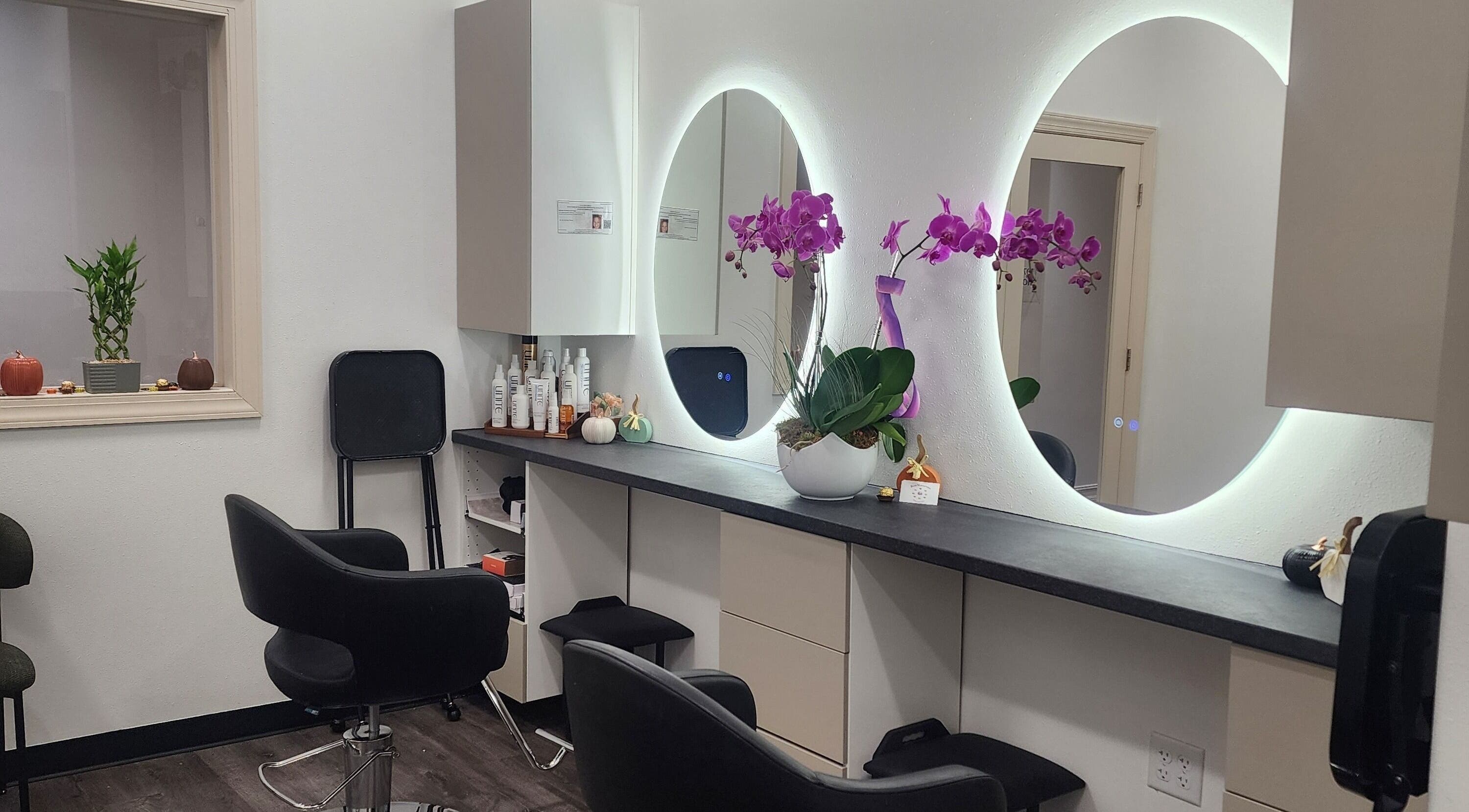 Modern salon interior at CHELLE HAIR DESIGN, Boca Raton, Florida, US, featuring stylish chairs and illuminated mirrors.