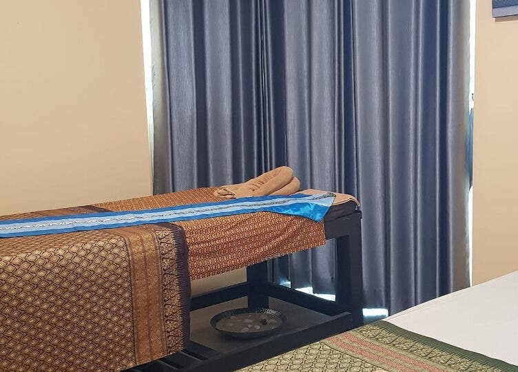 Relaxing massage room at Tharawadee Thai Massage and Spa, Swindon, England, GB with cozy bed and curtains.