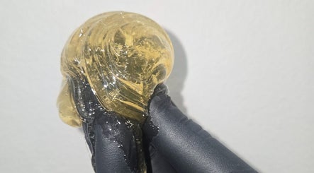 Close-up of sugaring paste at Sugar Chic Studios, Idaho Falls, Idaho, US, held in gloved hand.