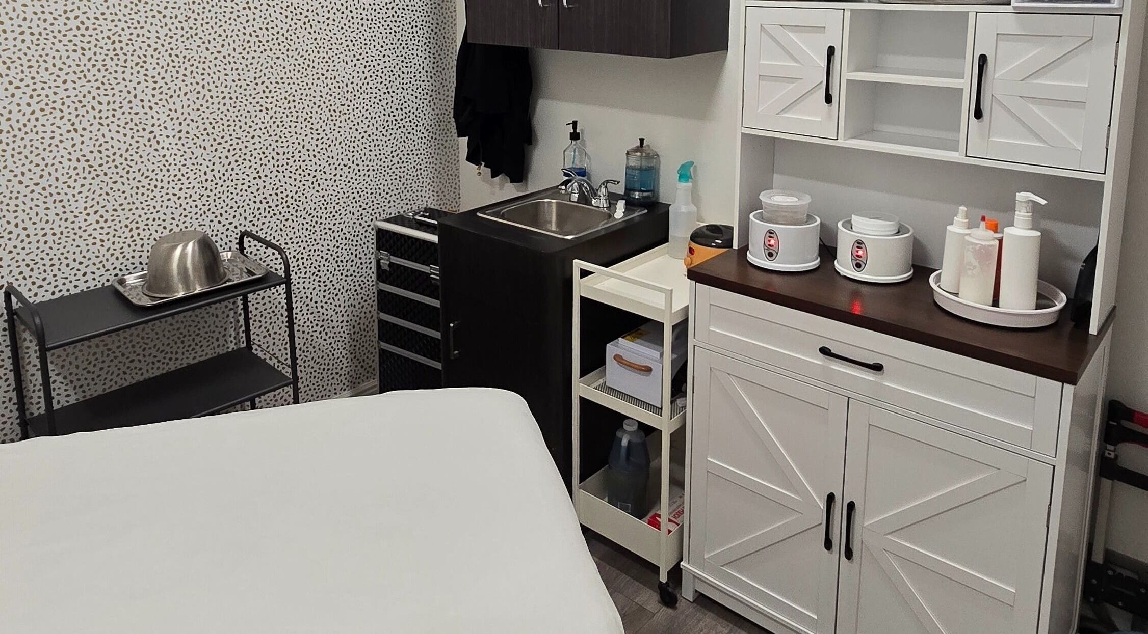 Cozy treatment room at Sugar Chic Studios in Idaho Falls, Idaho, US, featuring stylish storage and a sink.