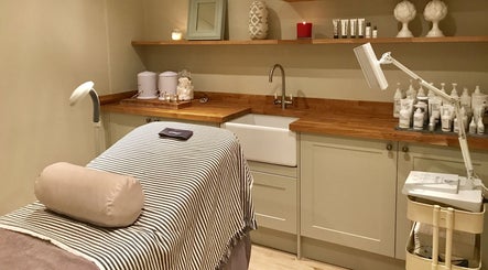 The Bothy spa room in York, England, GB featuring a treatment bed, skincare products, and warm lighting.