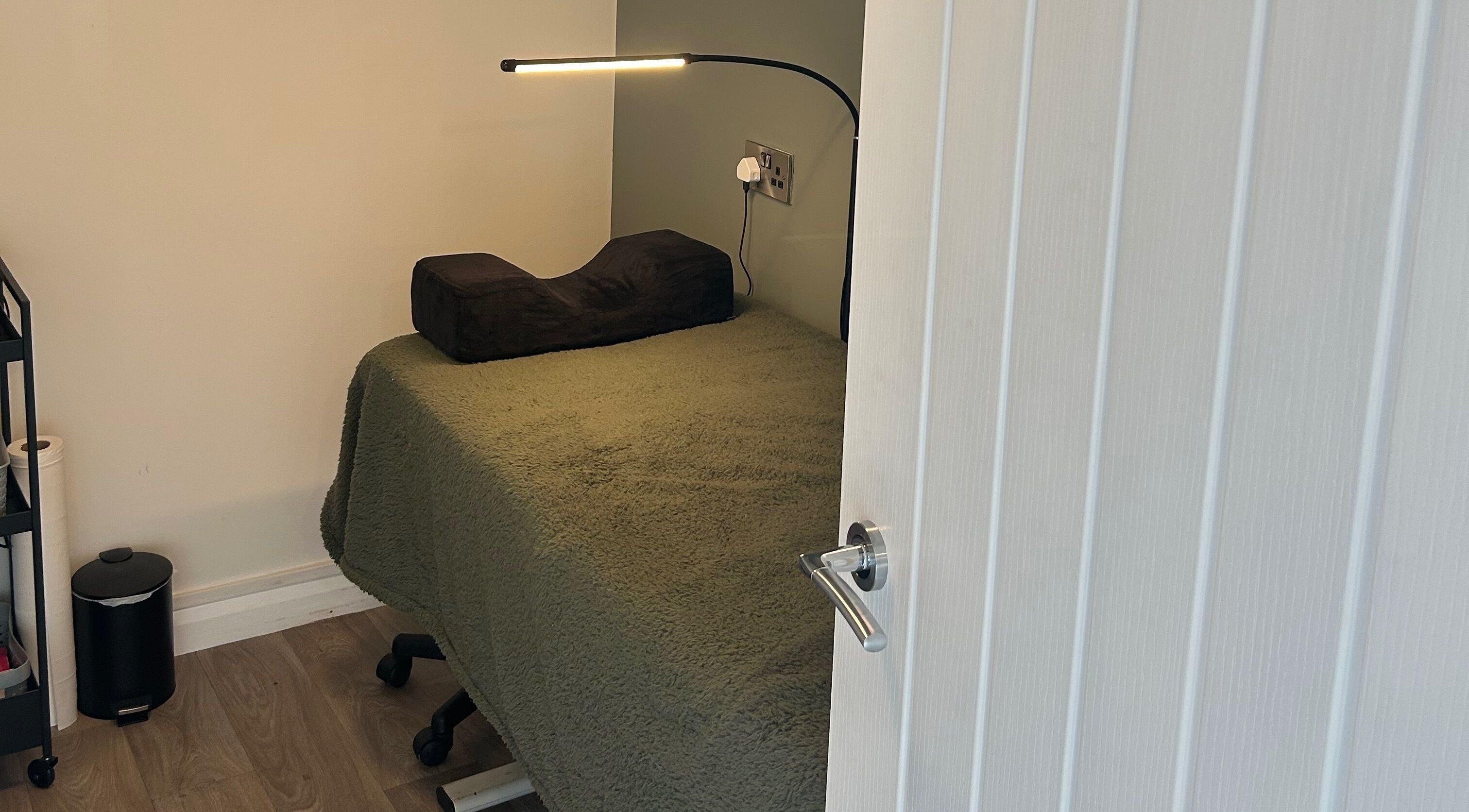 Relaxing therapy room at Prettyme Beauty Allestree, Derby, England, GB, with plush bedding and modern lighting.