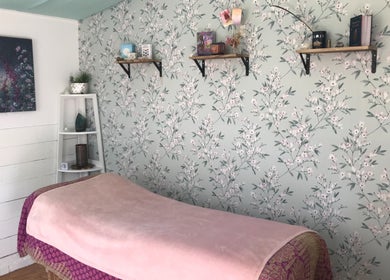 Calming therapy room at In8 Wellbeing, Milton Ernest, England, GB, with floral wallpaper and soft lighting.