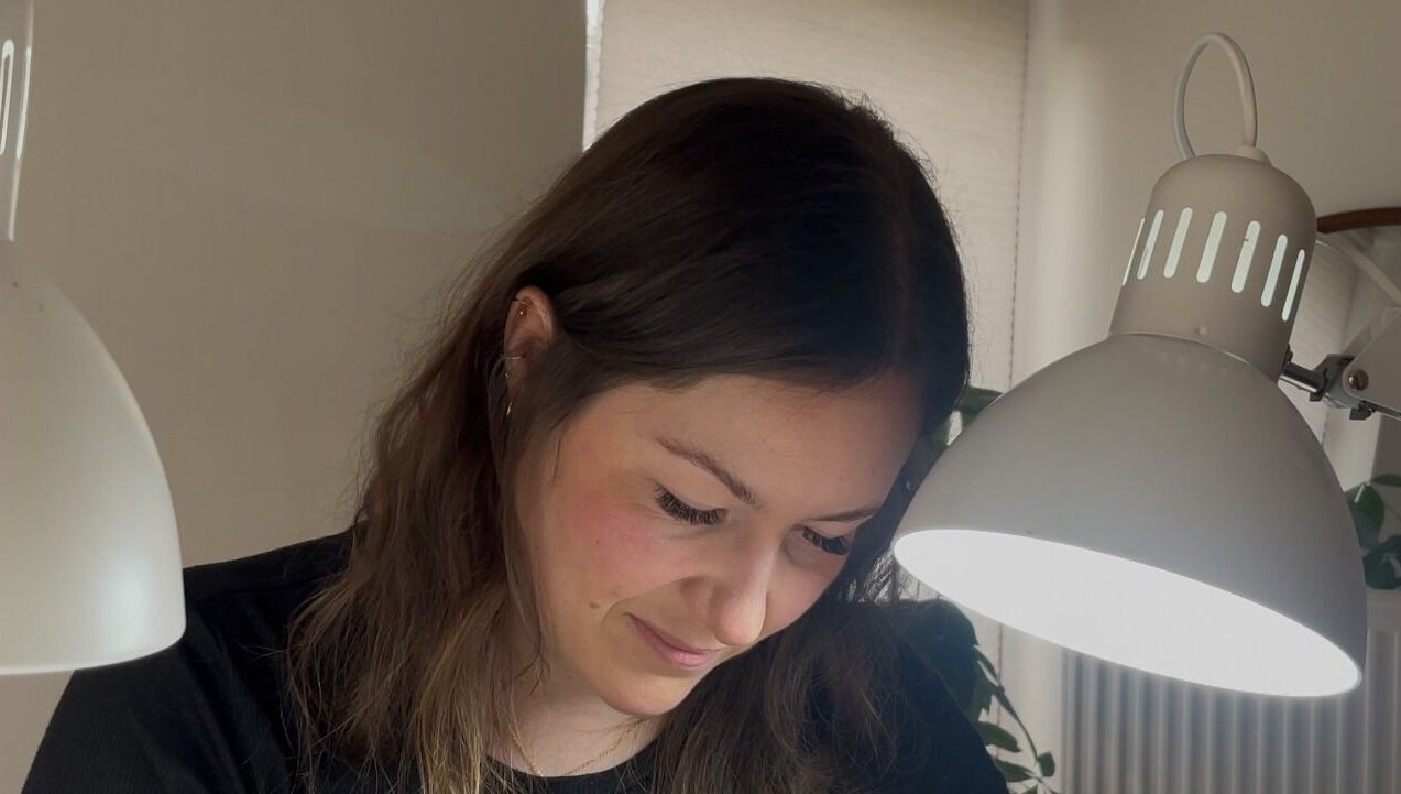 Technicienne concentrée chez NailsWithLove à Jemeppe-sur-sambre, Région Wallonne, BE sous une lampe de travail.