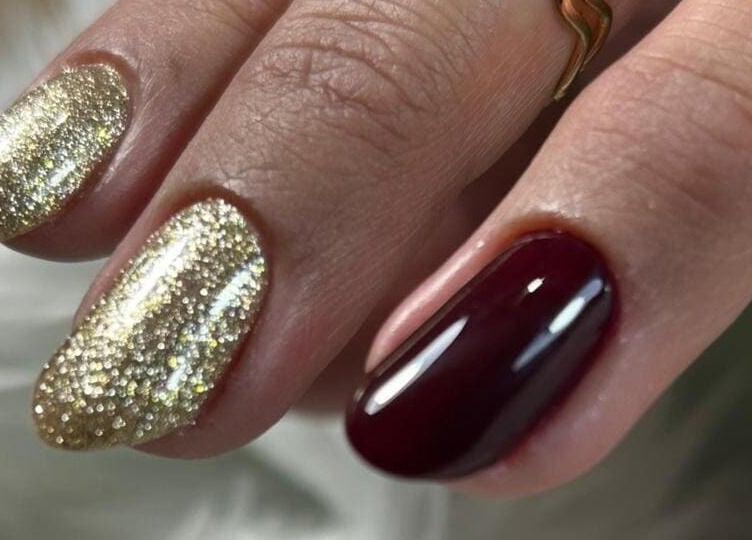 Diseño de uñas elegantes con brillo dorado y rojo en Denmnails, Maipú, Región Metropolitana, CL.