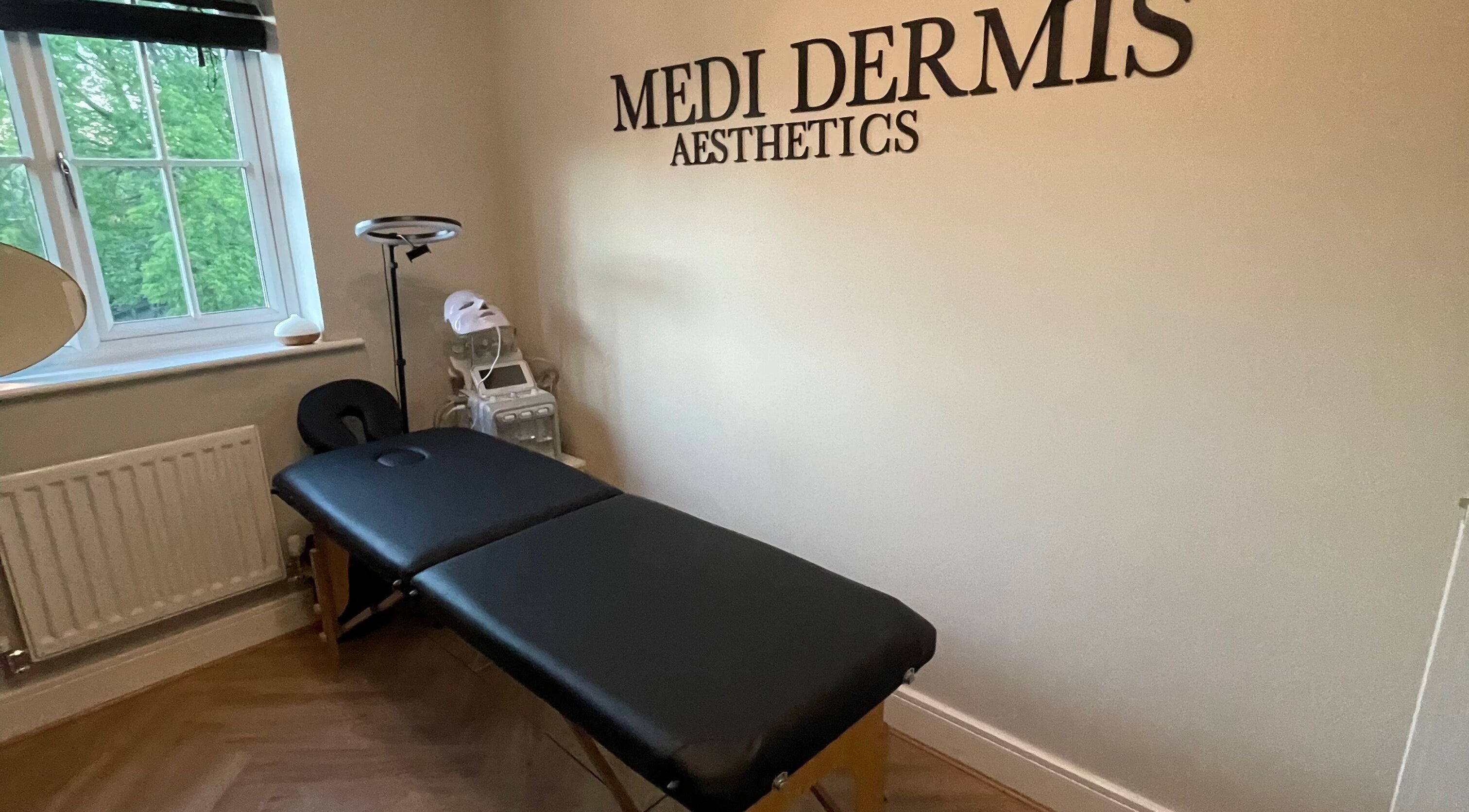 Relaxing treatment room at Medi Dermis Aesthetics in Chorley, England featuring a massage table.