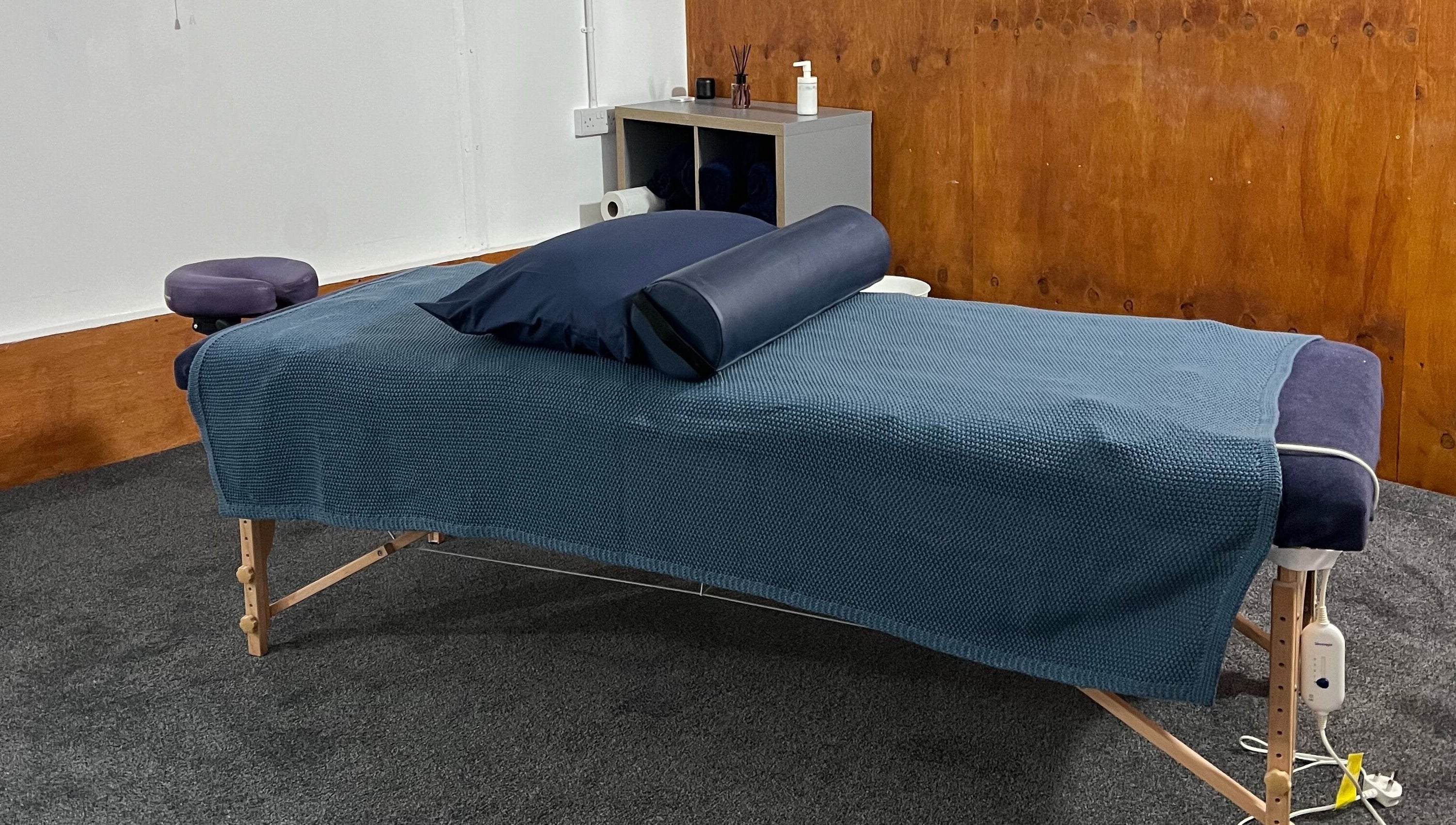 Cozy massage setup at CH Massage & Rehab, Poltimore, England, GB, featuring a blue-draped therapy table.