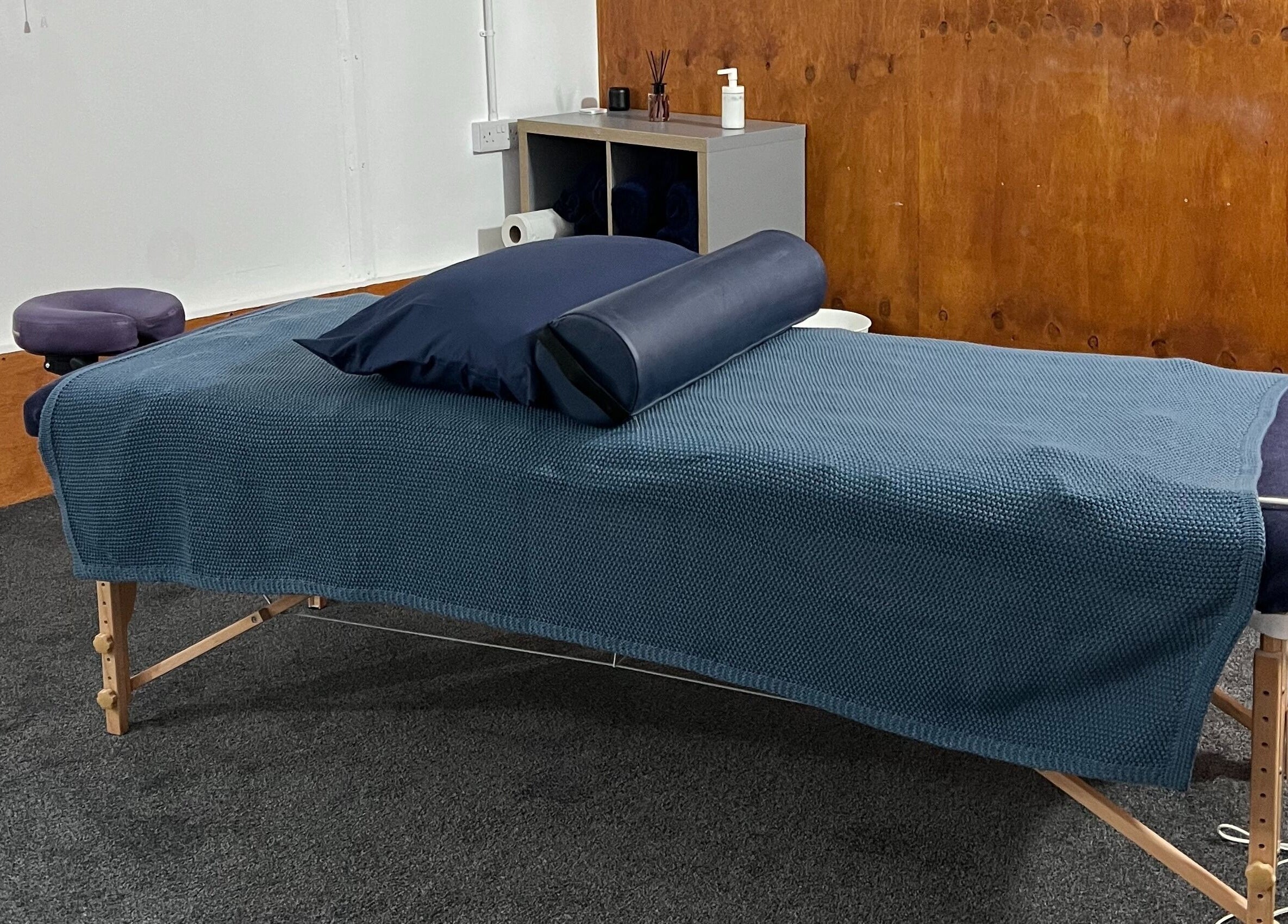 Cozy massage setup at CH Massage & Rehab, Poltimore, England, GB, featuring a blue-draped therapy table.
