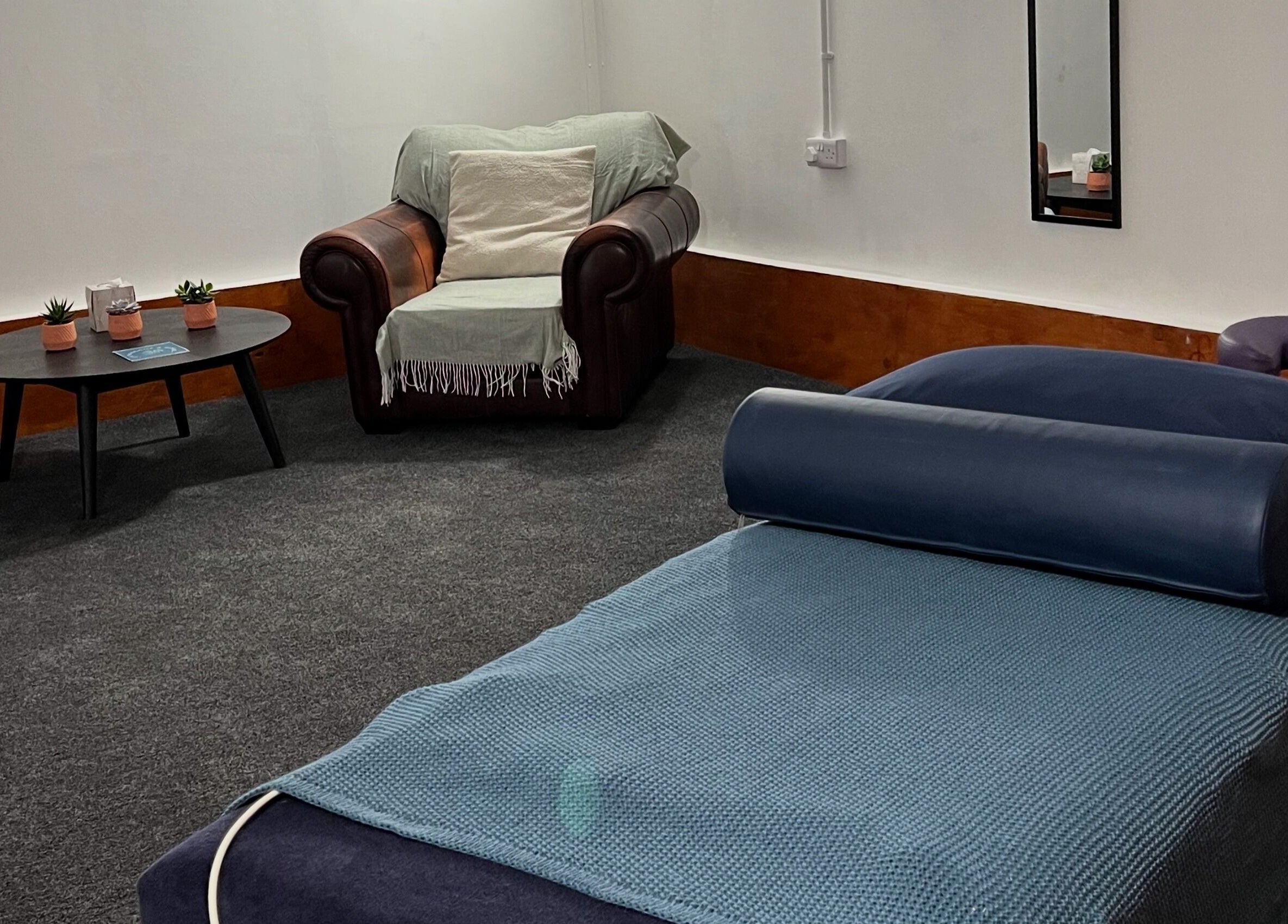 Relaxing therapy room at CH Massage & Rehab, Poltimore, England, GB, with a cozy chair and massage table.