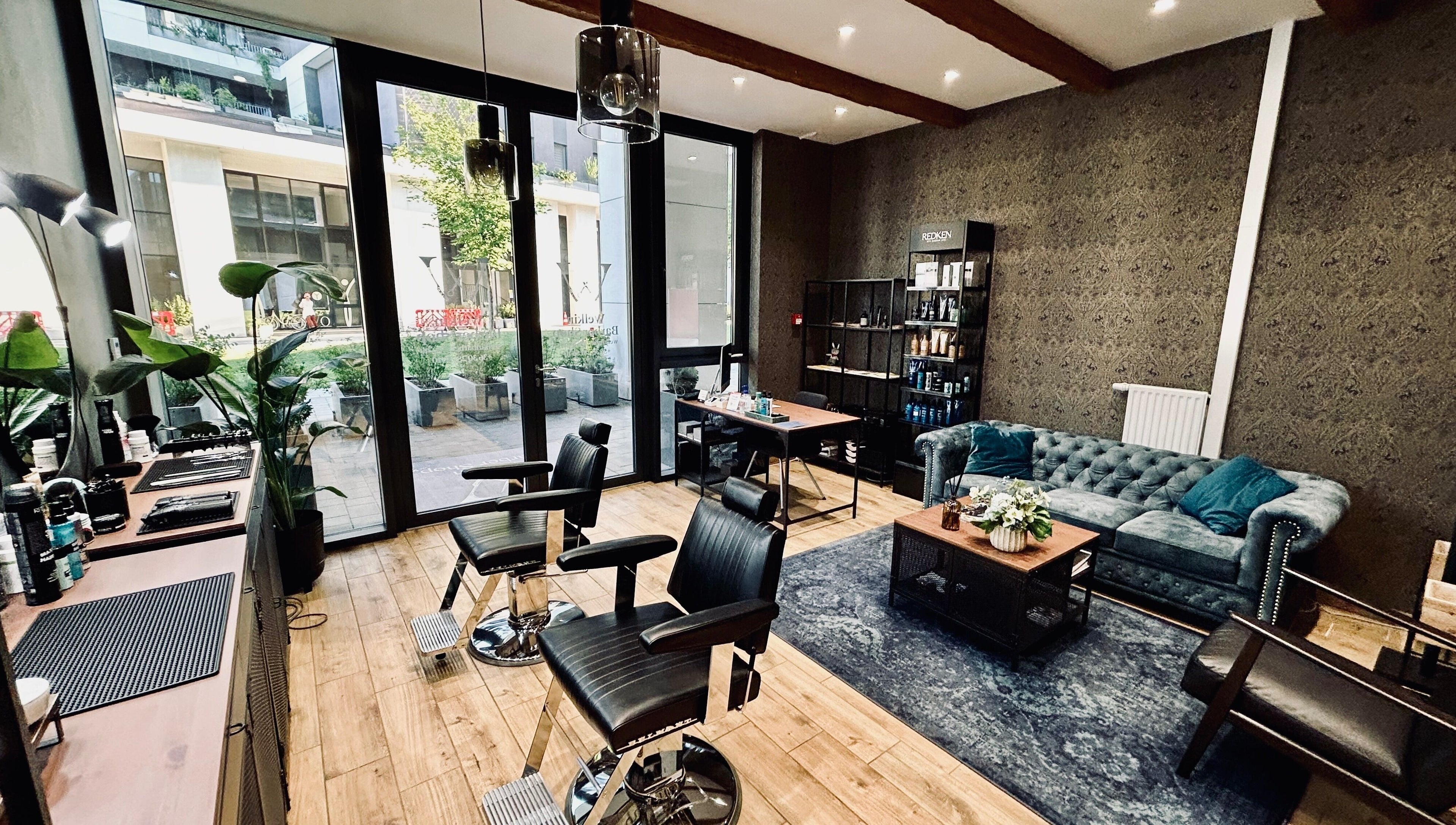 A Welkin Barber Shop belső tere Budapesten, elegáns bőrülésekkel és modern dekorációval.