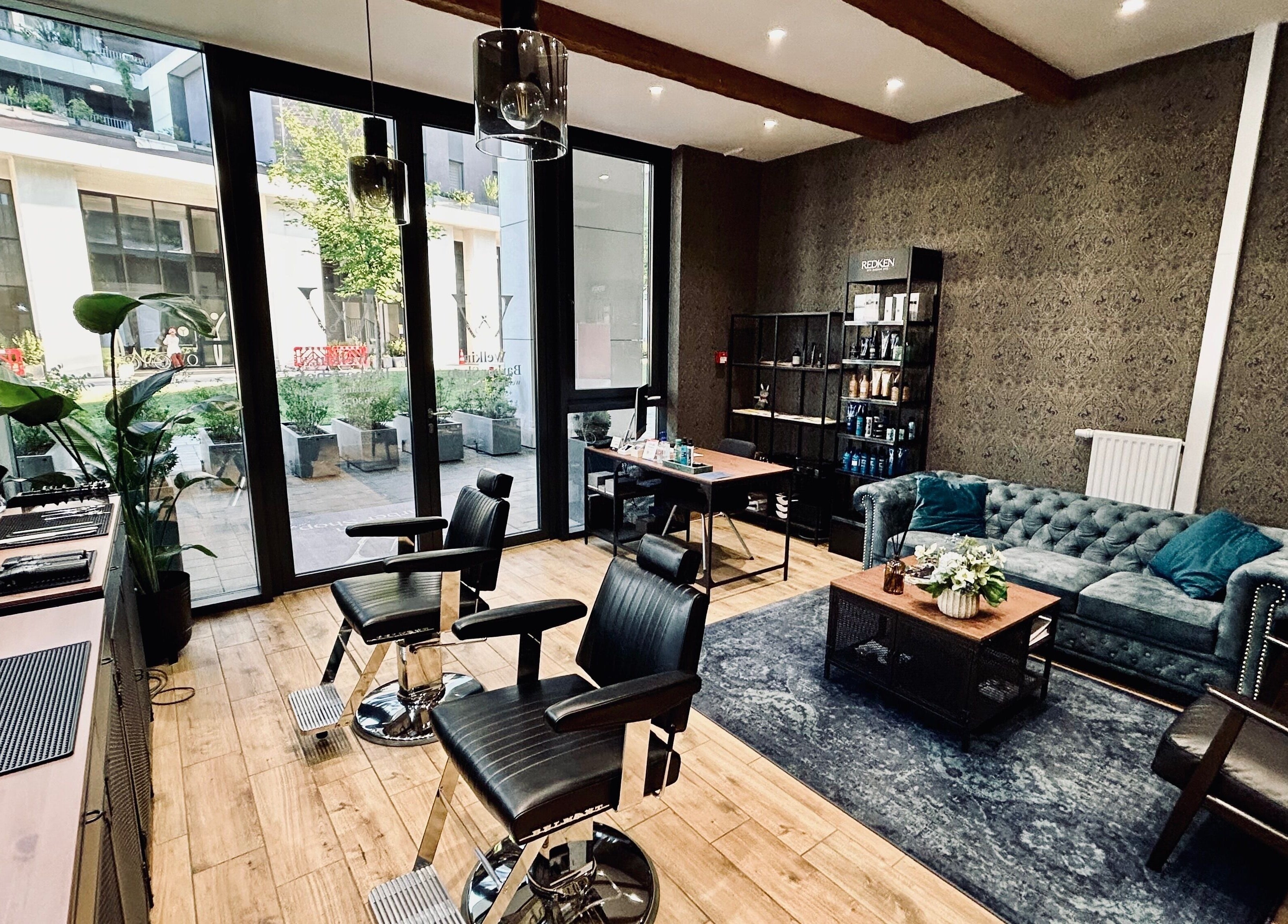 A Welkin Barber Shop belső tere Budapesten, elegáns bőrülésekkel és modern dekorációval.