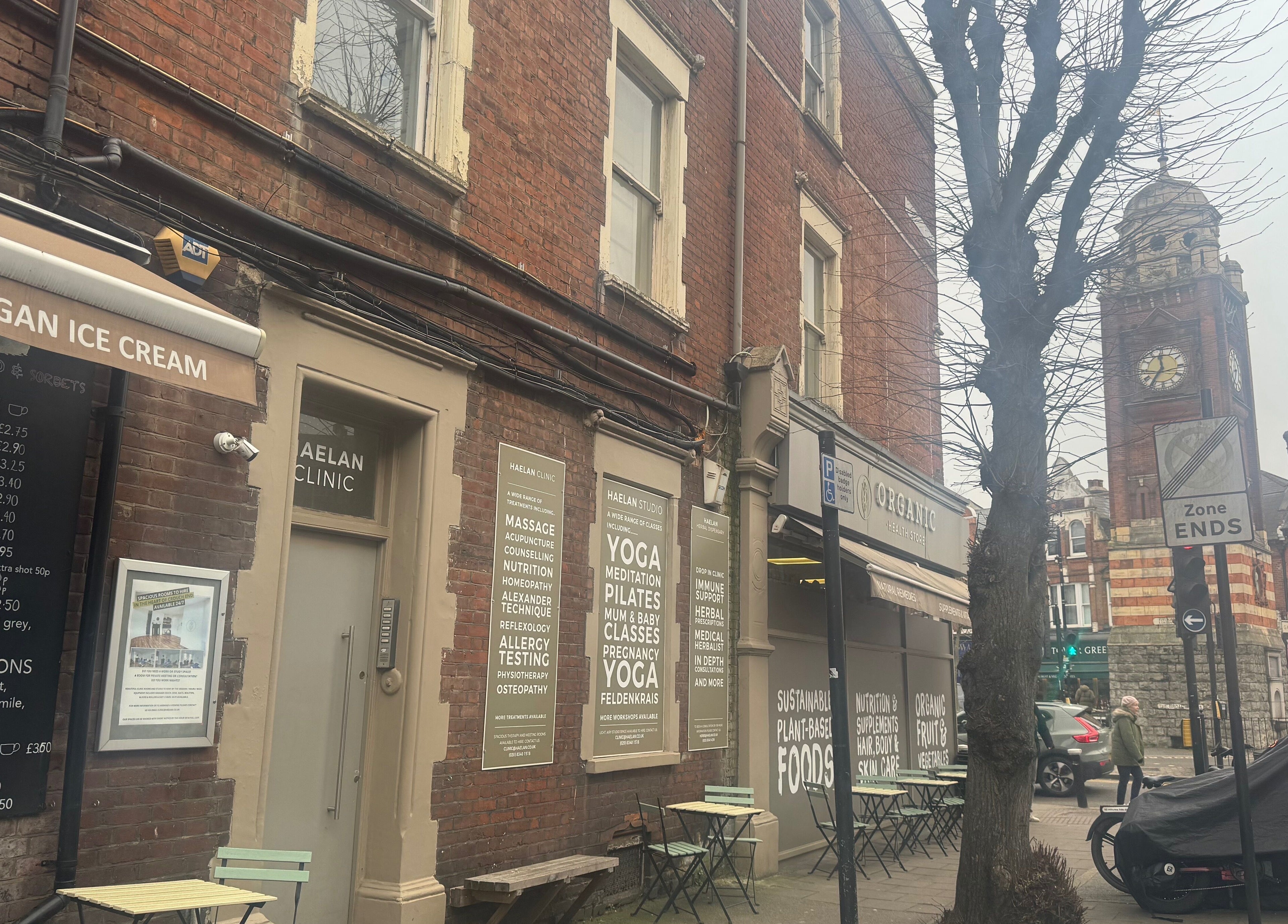 Street view near Face and Body Therapies by Christina in London, England, GB, featuring wellness shops and cafes.