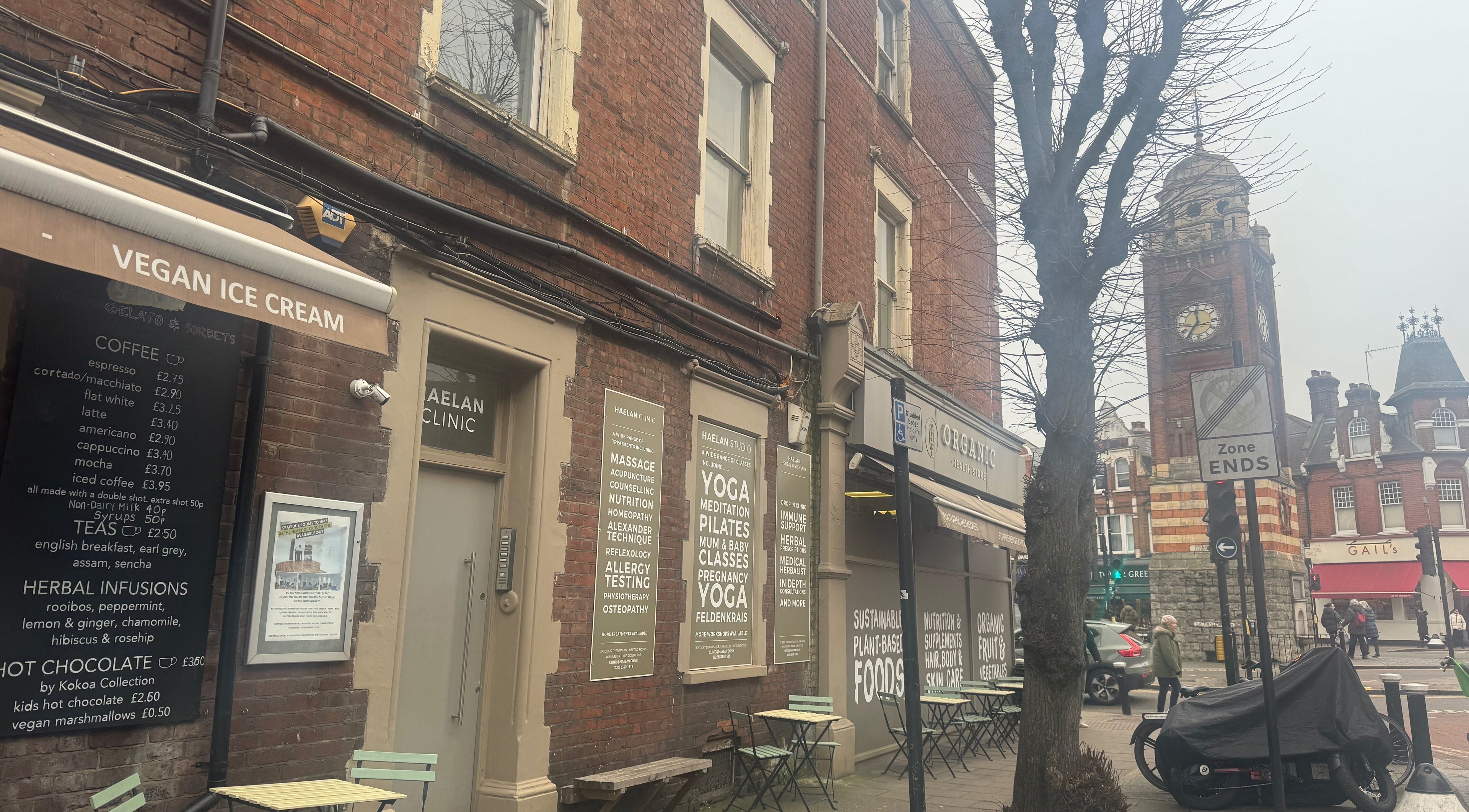 Street view near Face and Body Therapies by Christina in London, England, GB, featuring wellness shops and cafes.